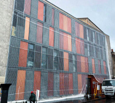 Pose d'un filet de sécurité pour la rénovation d'une façade d'un immeuble au centre ville par Acrobat Travaux, société de rénovation et cordiste sur Vieille Toulouse