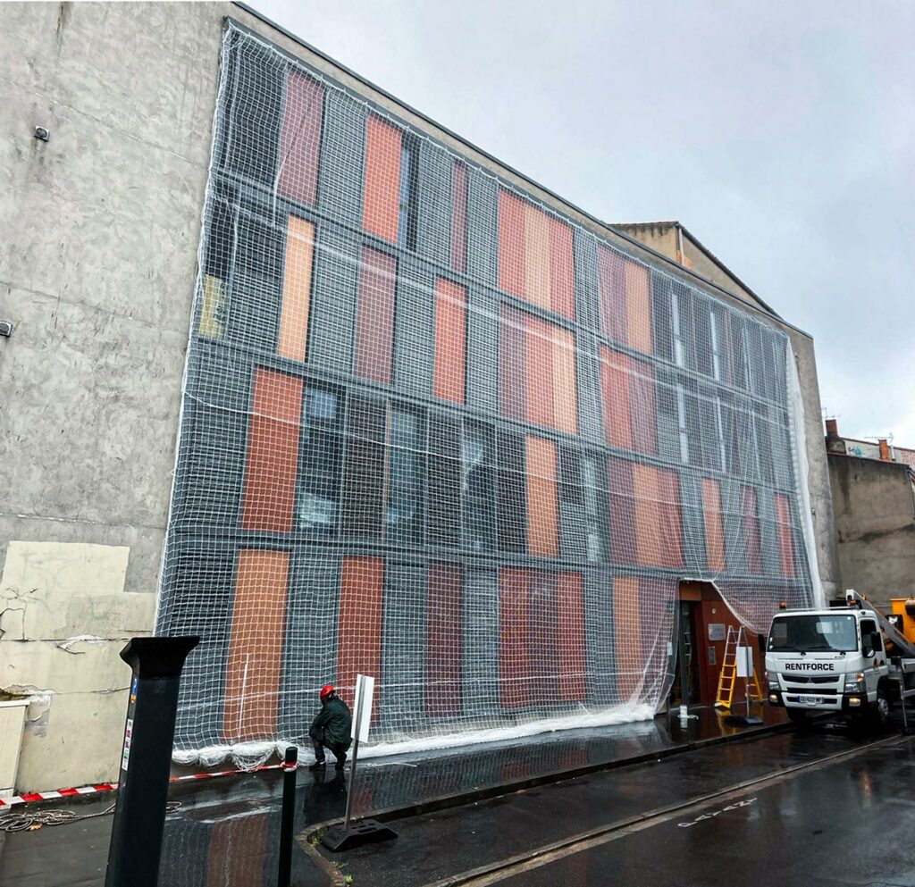 Pose d'un filet de sécurité pour la rénovation d'une façade d'un immeuble au centre ville par Acrobat Travaux, société de rénovation et cordiste sur Vieille Toulouse